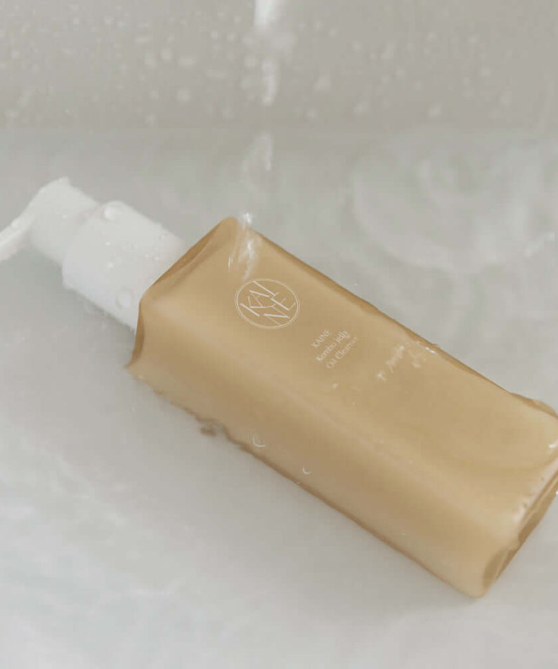 KAINE Kombu Jelly Oil Cleanser 145ml bottle in water, highlighting its luxurious formula and packaging.