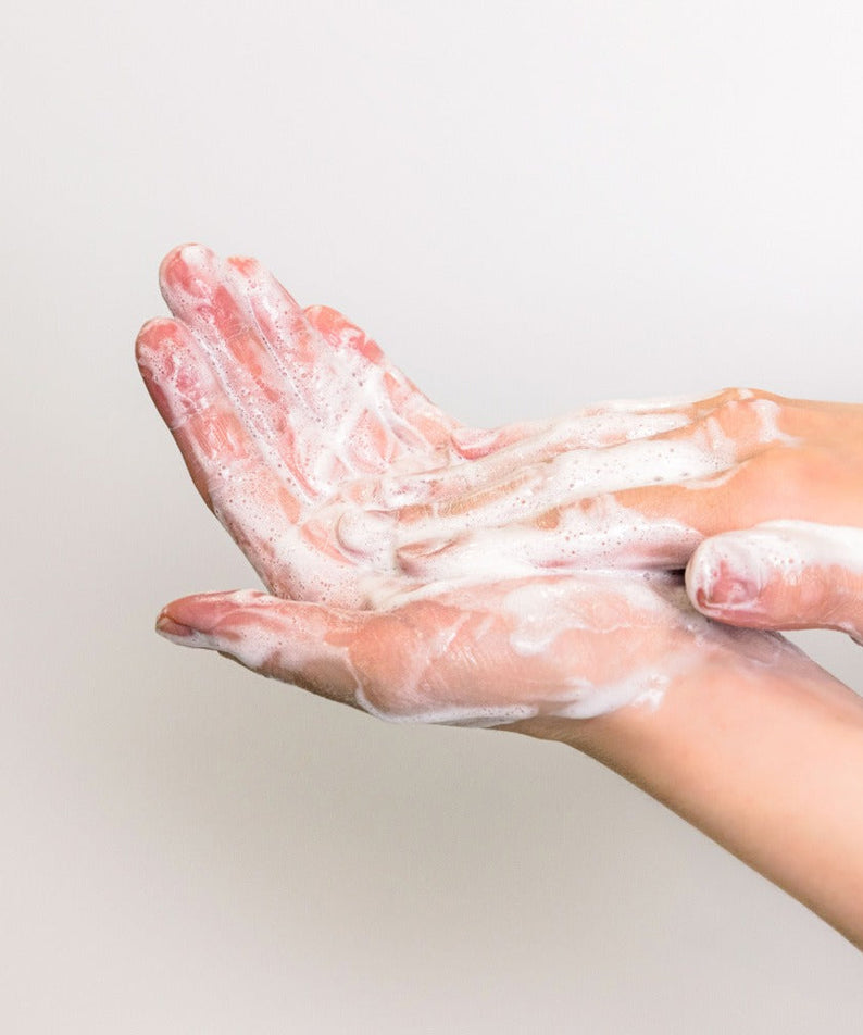 Hands lathered with foam using KAINE Rosemary Acne Mildly Acidic Cleansing Bar 100g, showing cleansing effectiveness.