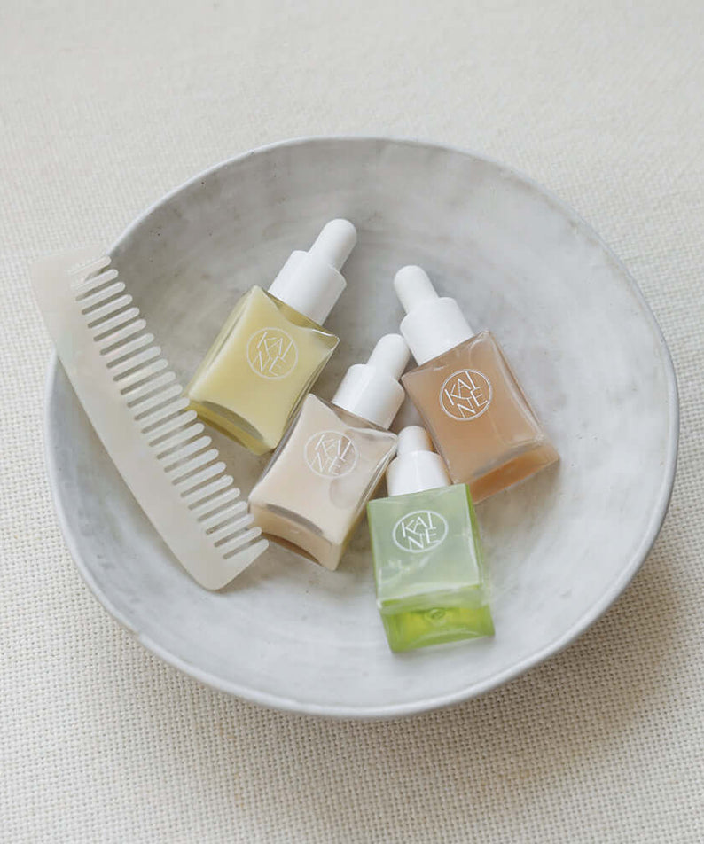 KAINE Serum Discovery Kit displayed with skincare serums and a comb in a dish for beauty routine.