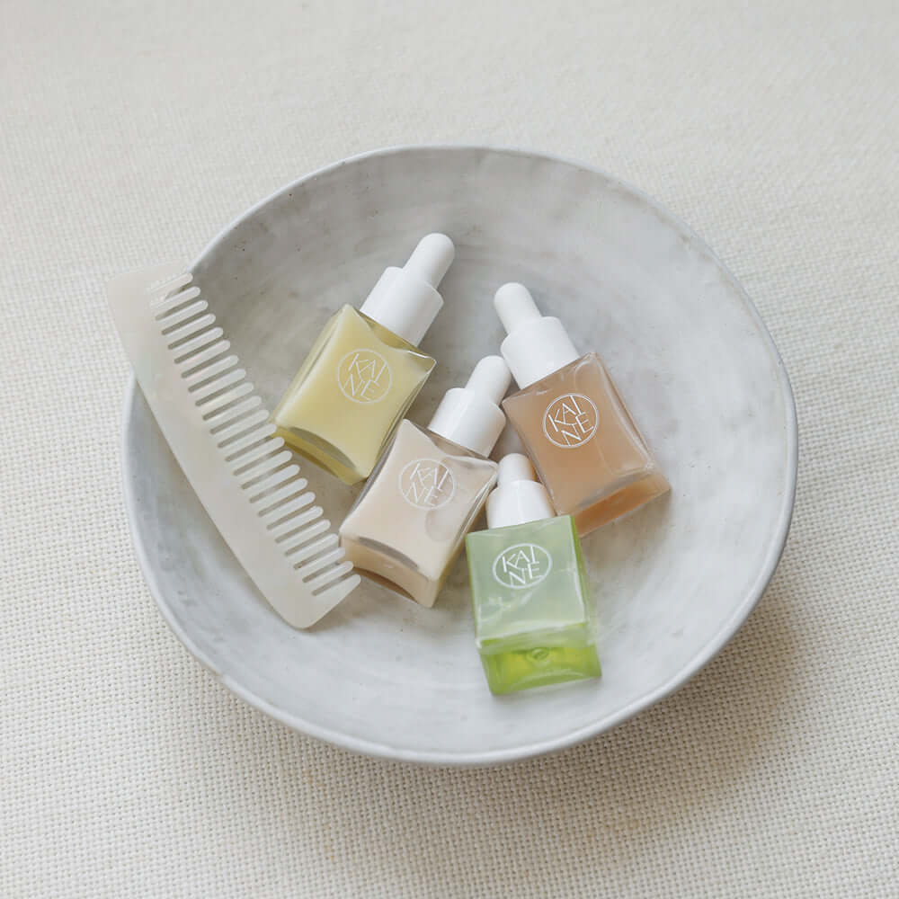 KAINE Serum Discovery Kit displayed with skincare serums and a comb in a dish for beauty routine.