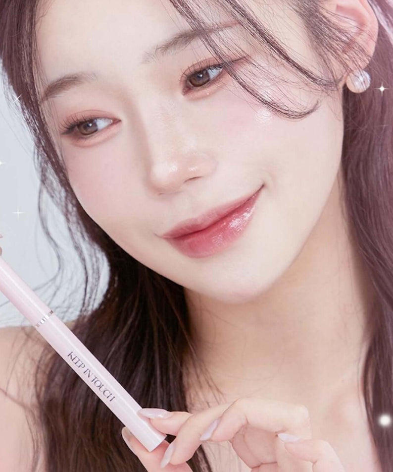 Woman applying KEEP IN TOUCH Glow Lip Sealer Pencil for a glossy finish.