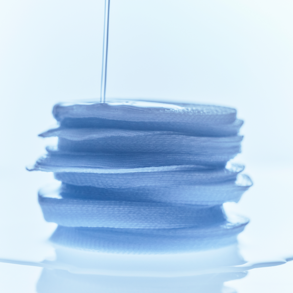 Stack of KLAIRS EGF Blue Calming Toner Pads 60 Pads with liquid being poured