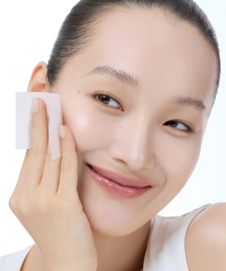 Woman using KLAIRS Freshly Juiced Vitamin Hwajalmeok Pad 80 sheets on her face for a glowing complexion.