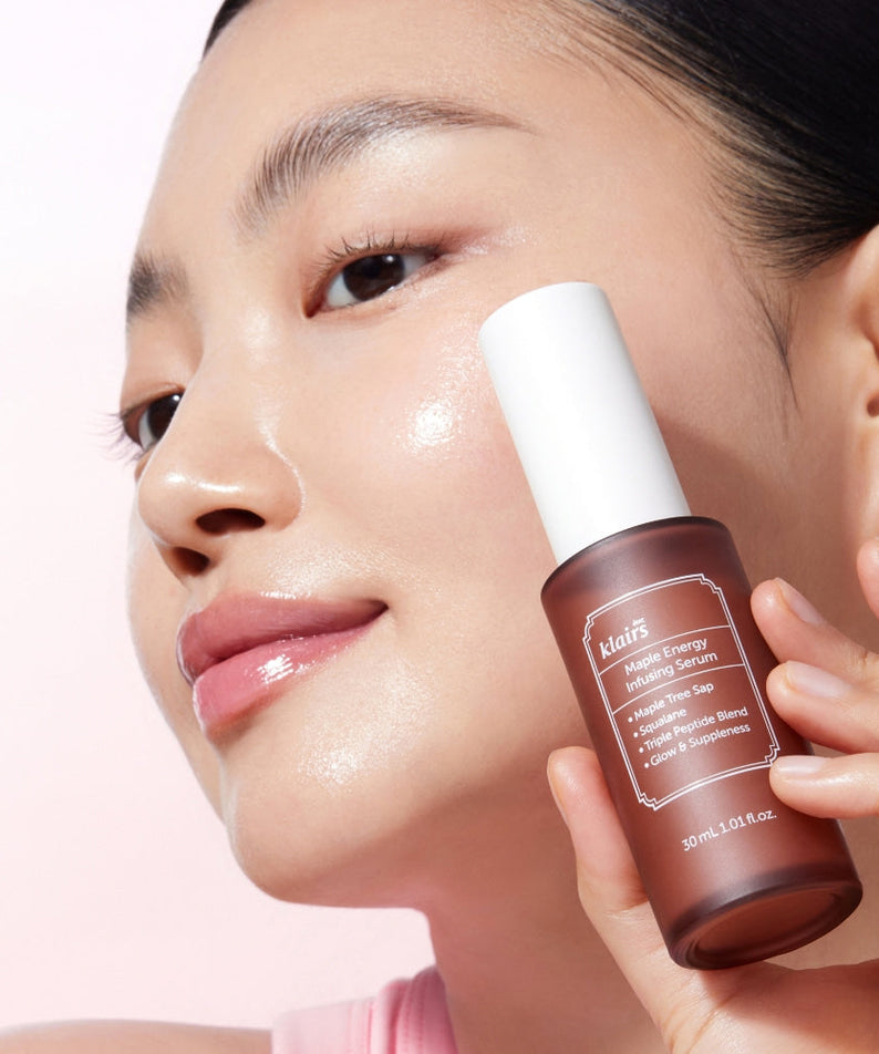 Woman holding KLAIRS Maple Energy Infusing Serum 30ml against her face