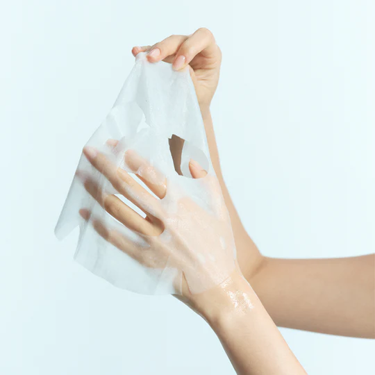 Hands holding KLAIRS Vitamin Vitality Sheet Mask 25ml 1sheet against a light background.