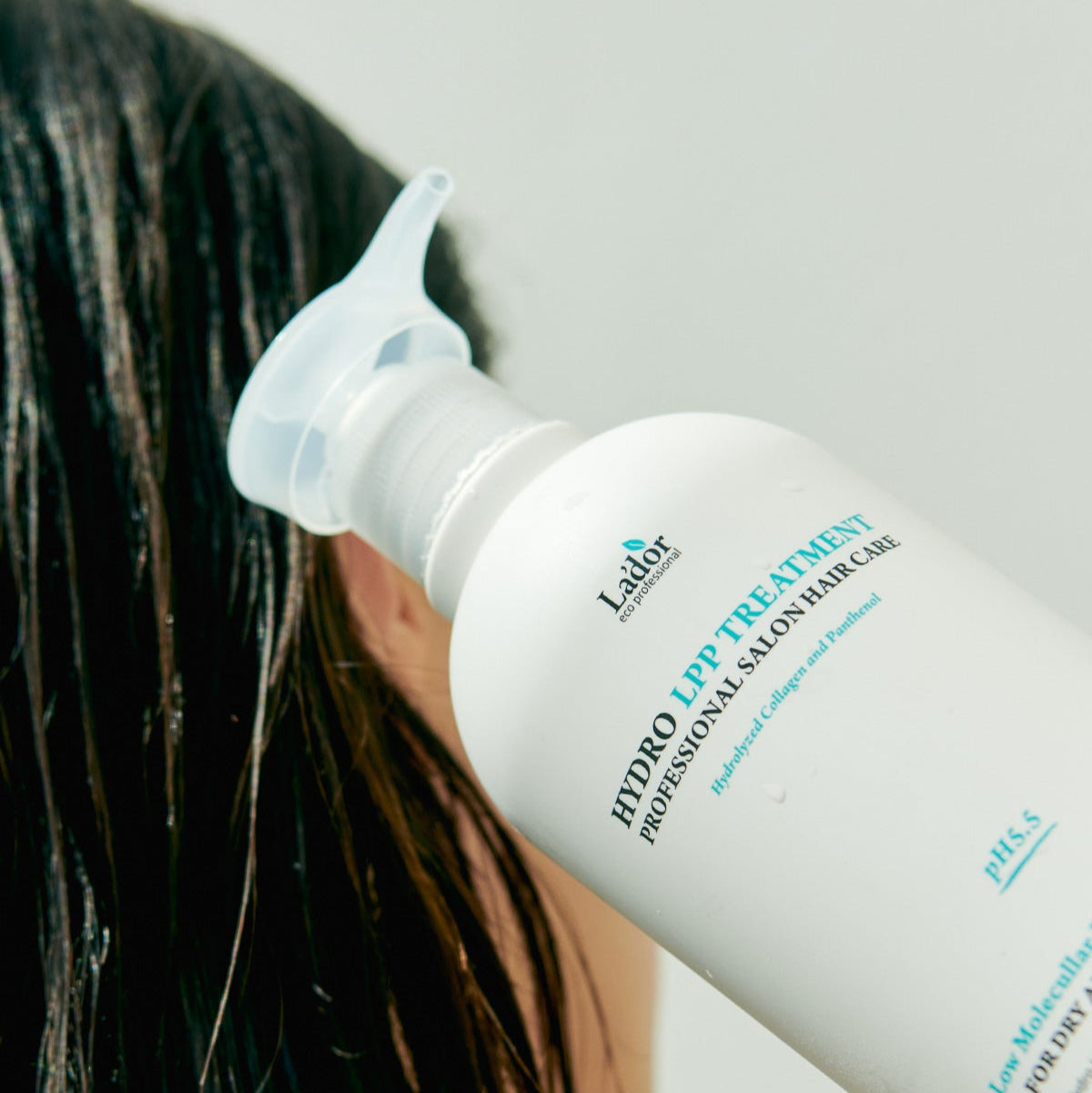 LADOR Hydro LPP Protein Treatment 530ml being applied to wet hair for salon-quality care.