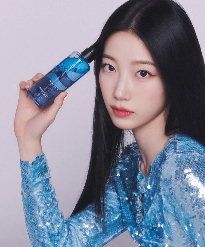 Woman holding LADOR Keratin Perfume Hair Mist 130ml with sleek hair, showcasing the product's elegance and style.