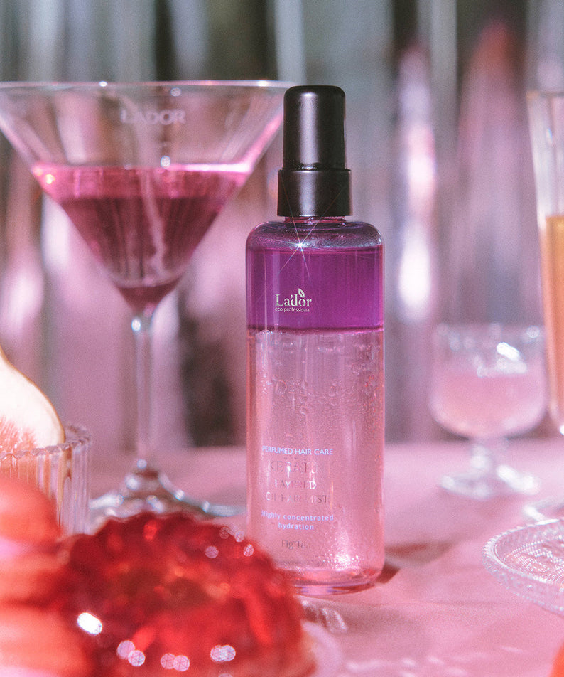 LADOR Keratin Perfume Hair Mist 130ml bottle displayed among elegant glassware and soft lighting