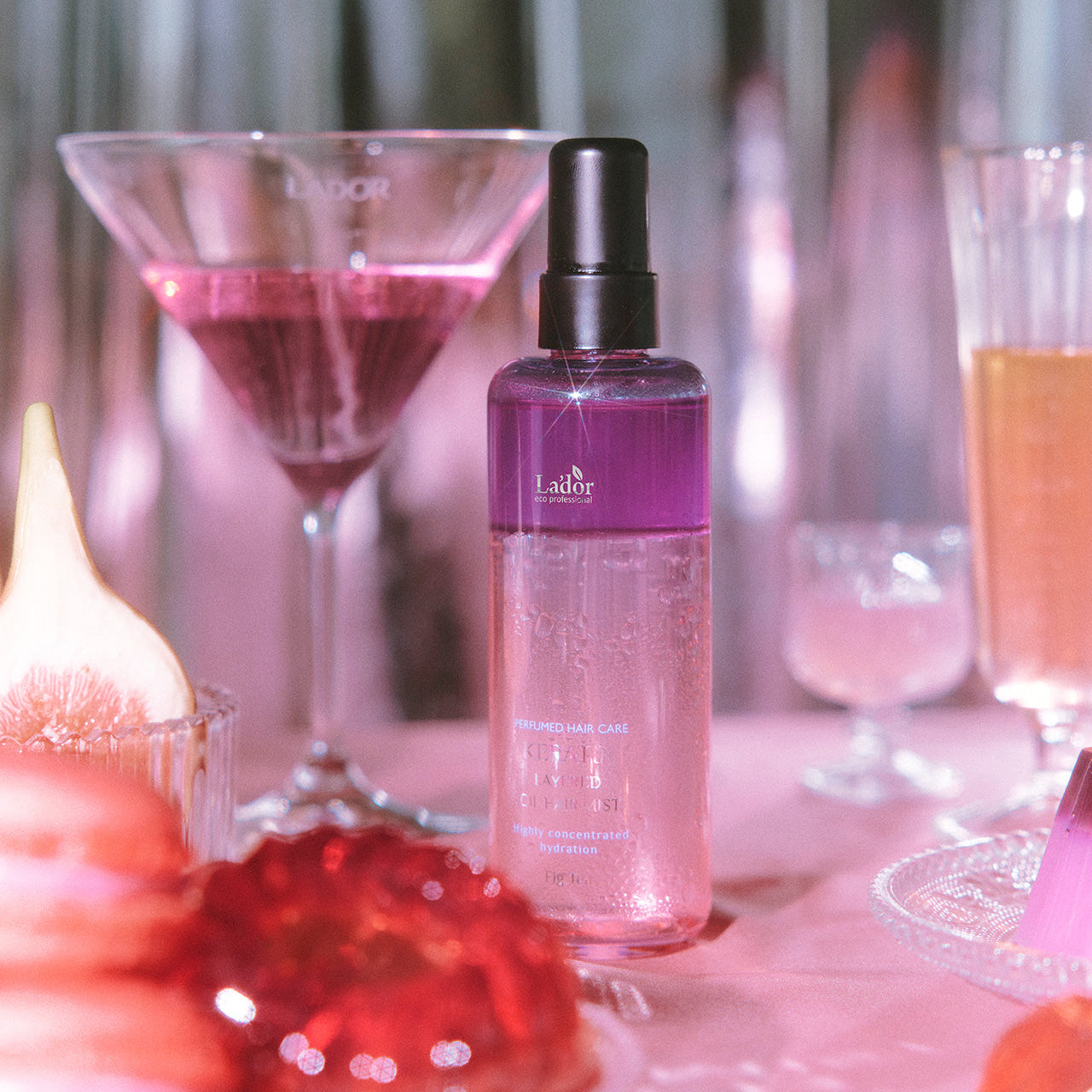 LADOR Keratin Perfume Hair Mist 130ml bottle displayed among elegant glassware and soft lighting