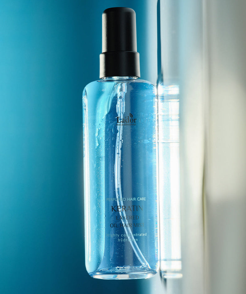 LADOR Keratin Perfume Hair Mist 130ml bottle with blue liquid on reflective surface