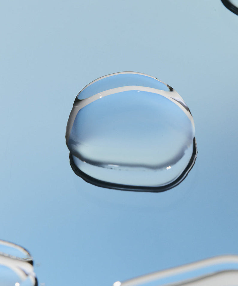 Close-up of liquid on surface, representing the LADOR Perfect Hair Fill-Up 150ml product texture and hydration benefits
