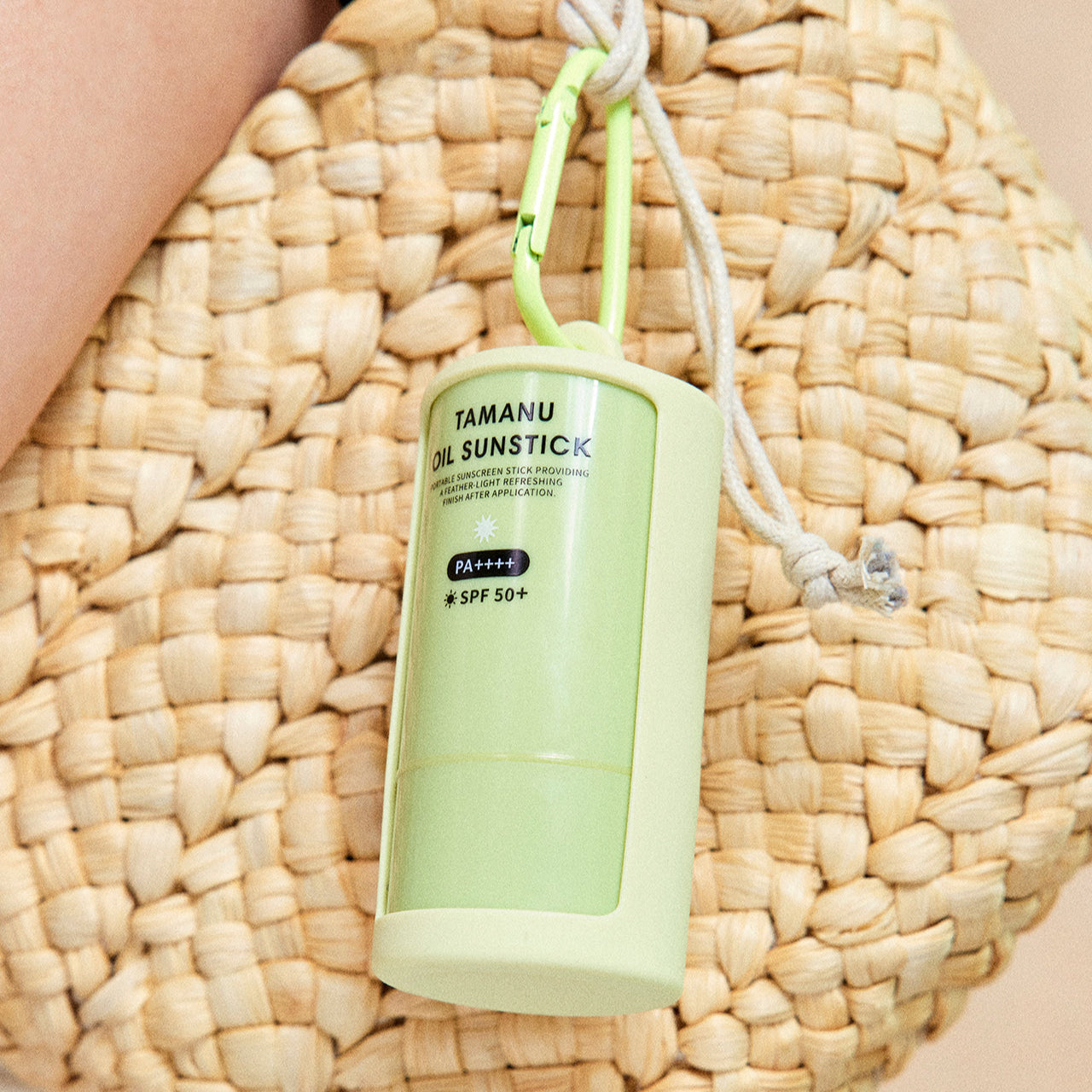 LADOR Tamanu Oil Sun Stick 21g hanging on a woven bag showing its portable design and SPF protection level.