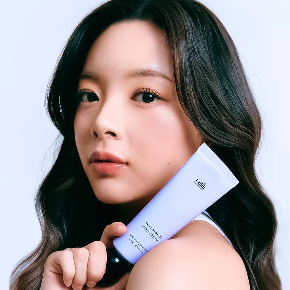 Woman holding LADOR Volumizing Curl Cream 80ml for enhancing curls and adding volume to hair, beauty hair care product