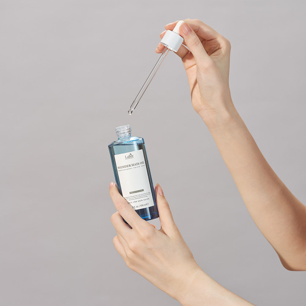 LADOR Wonder Hair Moisture Oil 100ml bottle and dropper for nourishing hair care.