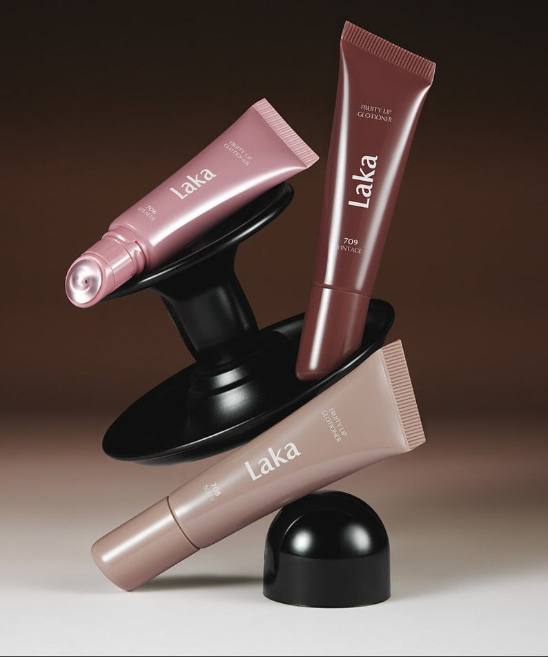 Three tubes of LAKA Fruity Lip Glossionner showcased on a stylish black stand with elegant design and vibrant colors.
