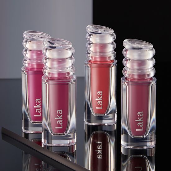 Four shades of LAKA Maxi Glayer Tint lipsticks displayed on a reflective surface.