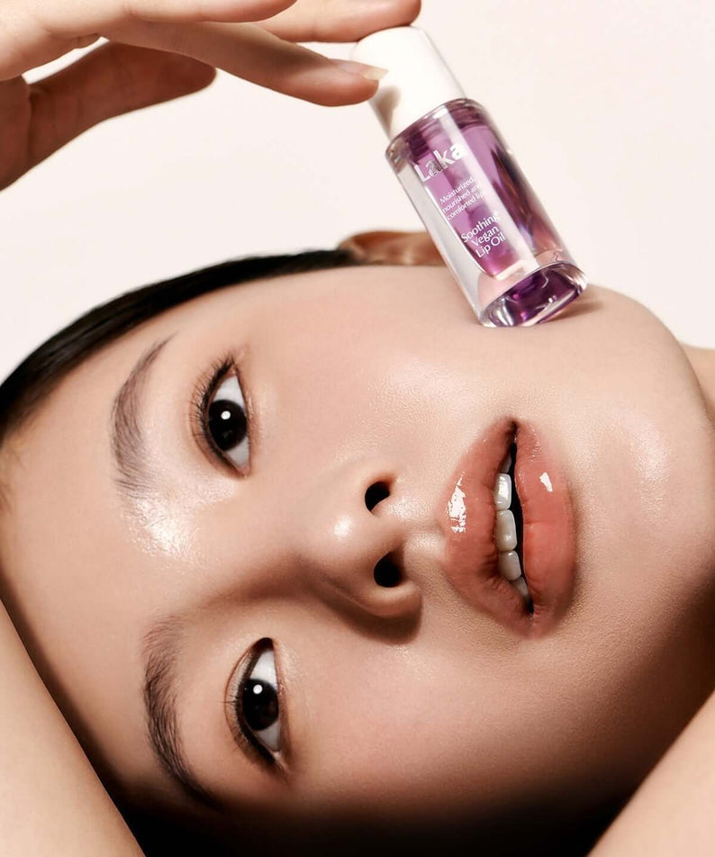 Model with LAKA Soothing Vegan Lip Oil against her face showcasing glossy lips and smooth skin.