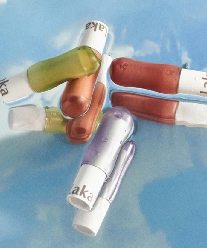 A selection of colorful LAKA Soul Vegan Lip Balm tubes on a blue background.