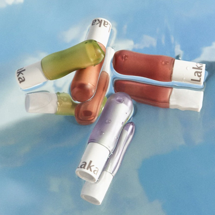 A selection of colorful LAKA Soul Vegan Lip Balm tubes on a blue background.