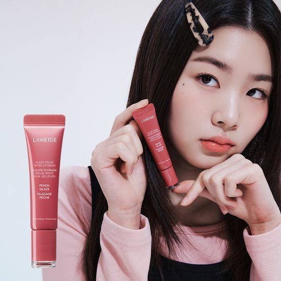 Model applying LANEIGE Glaze Craze Tinted Lip Serum, showcasing the product's packaging and color.