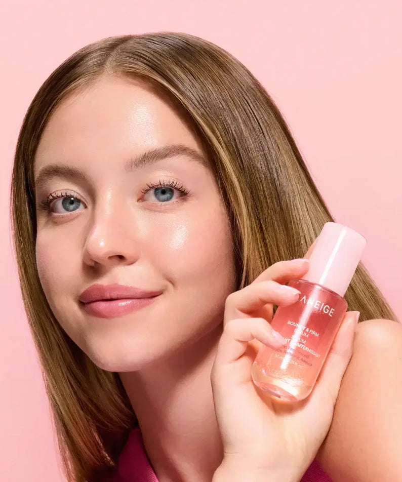 Person holding LANEIGE NEW Bouncy & Firm Serum 30ml with a pink background.