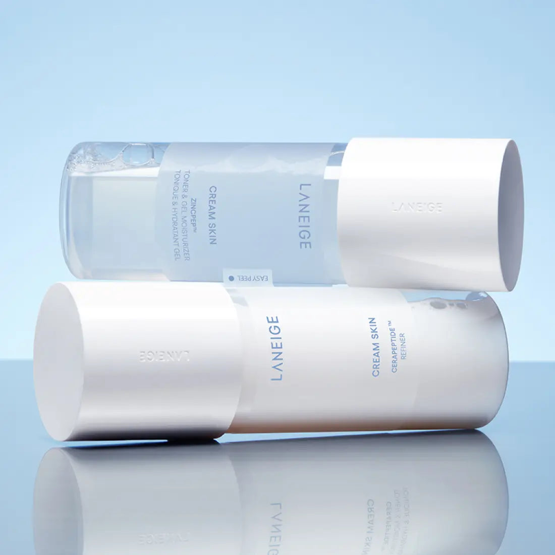 LANEIGE NEW Gel Cream Skin 170ml bottles stacked on a blue reflective surface, showcasing the sleek minimalist design.