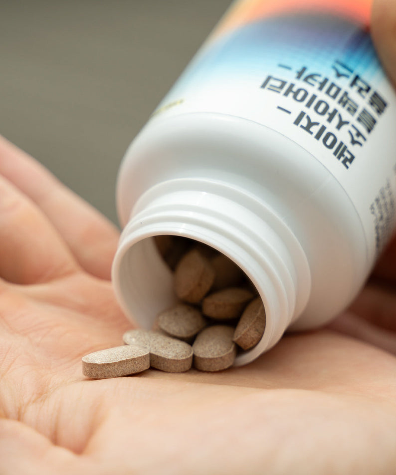 LAZY SOCIETY 1 Black + Multivitamin Set bottle pouring tablets into a gentleman’s hand, Korean skincare supplement by Gentleman Korea