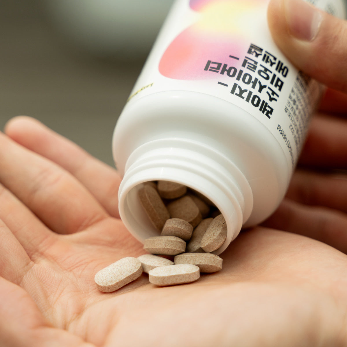 LAZY SOCIETY Biotin Essentail Wholesale - Gentleman Korea product shot of pills poured from bottle into hand, Korean skincare supplement for men