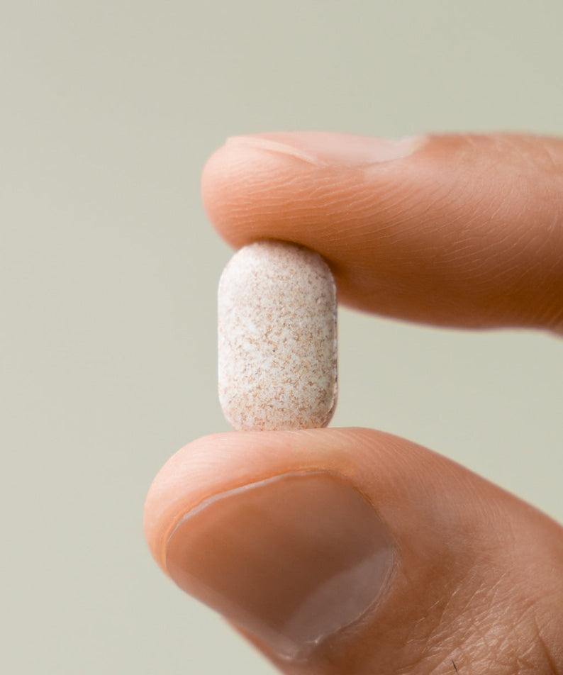 LAZY SOCIETY Biotin Essentail Wholesale - Gentleman Korea men's skincare biotin tablet close-up held between fingers