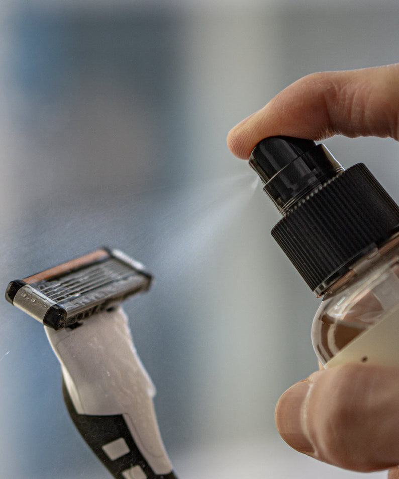 LAZY SOCIETY Razor Blade Sanitizer 120ml being sprayed on a razor blade by Gentleman Korea for men's grooming