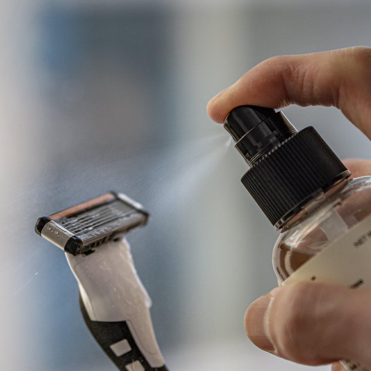 LAZY SOCIETY Razor Blade Sanitizer 120ml being sprayed on a razor blade by Gentleman Korea for men's grooming