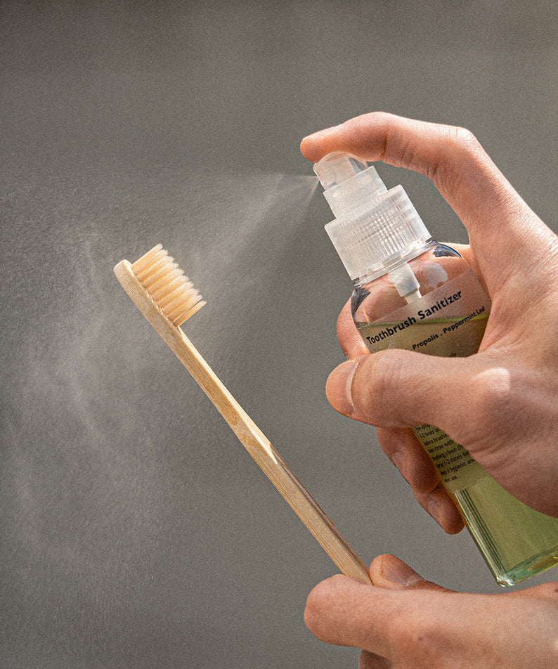 LAZY SOCIETY Toothbrush Sanitizer 100ml spray being applied to a bamboo toothbrush by Gentleman Korea for men’s oral care