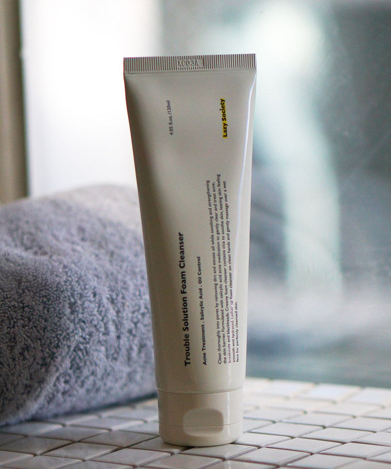 LAZY SOCIETY Trouble Solution Foam Cleanser 120ml tube on bathroom tile beside towel — Gentleman Korea men’s skincare product