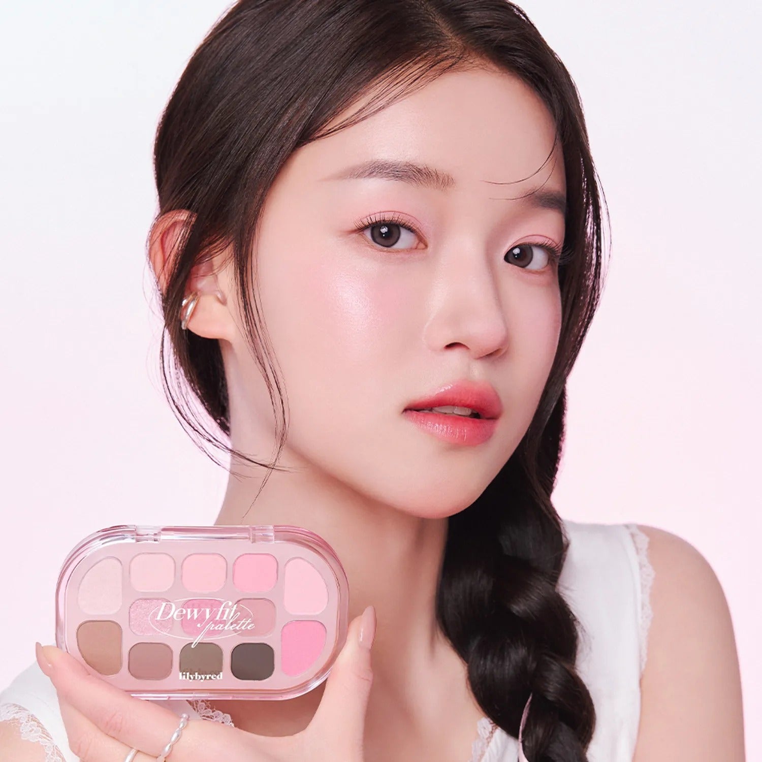 Woman holding LILYBYRED Dewy Fit Palette, featuring a range of soft pink and neutral shades for a dewy makeup look.
