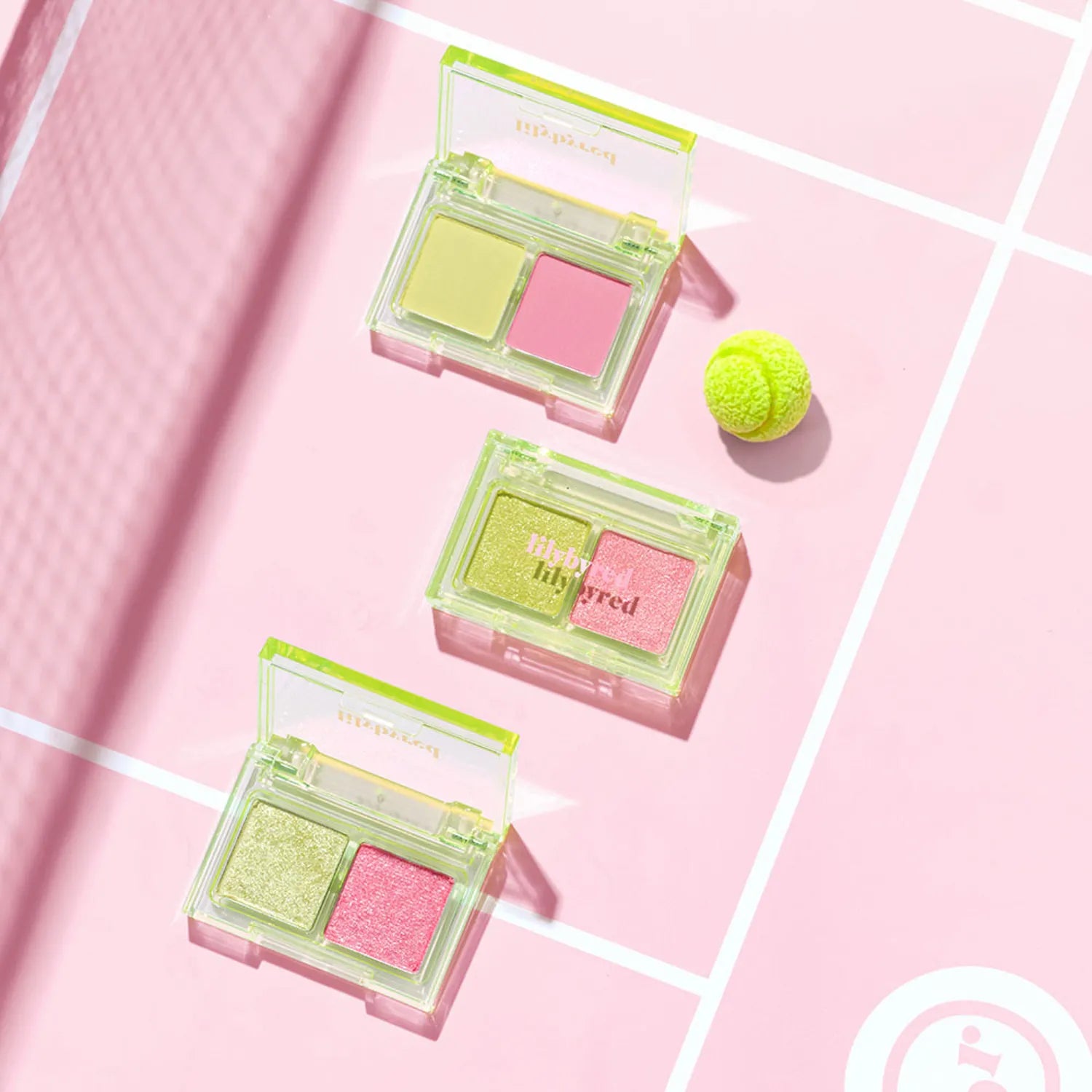 LILYBYRED Little Bitty Moment Shadow with vibrant eye shadow shades on a pink background with a green tennis ball.