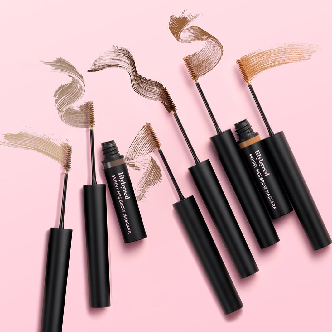LILYBYRED Skinny Mes Brow Cara in multiple shades on a pink background