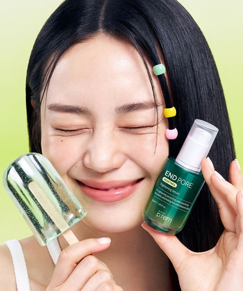 Smiling woman holding MAKE P:REM Endpore Vegetinol Tightening Serum 50ml with a dropper on green background