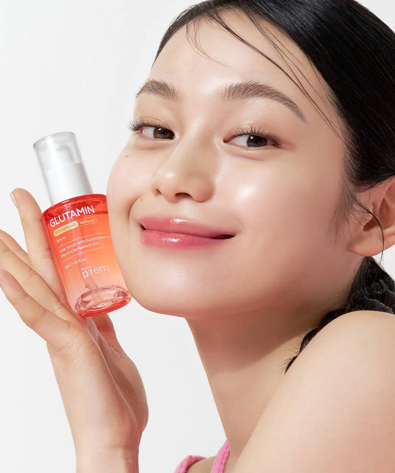 Woman holding MAKE P:REM Glutamine Antioxidant Radiance Serum 50ml bottle, showcasing skincare radiance