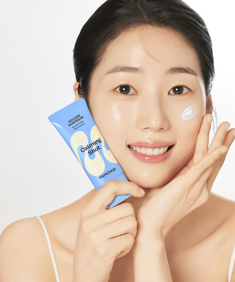 Woman applying MAMONDE Calming Shot Azulene Sun Cream SPF50+PA++++ 35ml with glowing skin