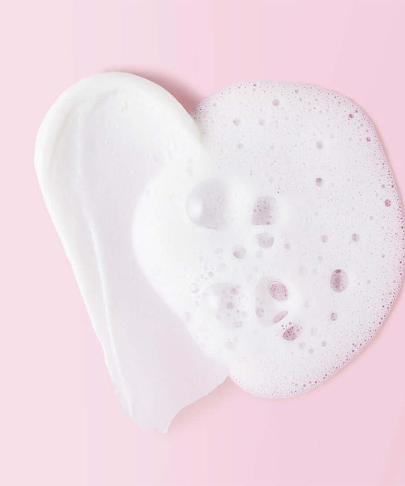 Texture of MAMONDE Ceramide Amino Foam 120g on a pink background, showing smooth lather and creamy foam ideal for gentle cleansing.