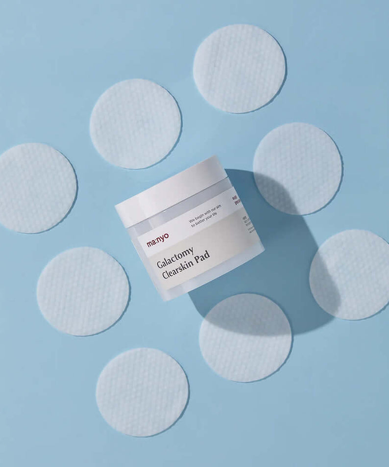 MANYO Galactomy Clear Skin Pads 60 sheets jar surrounded by open pad circles on a blue background.