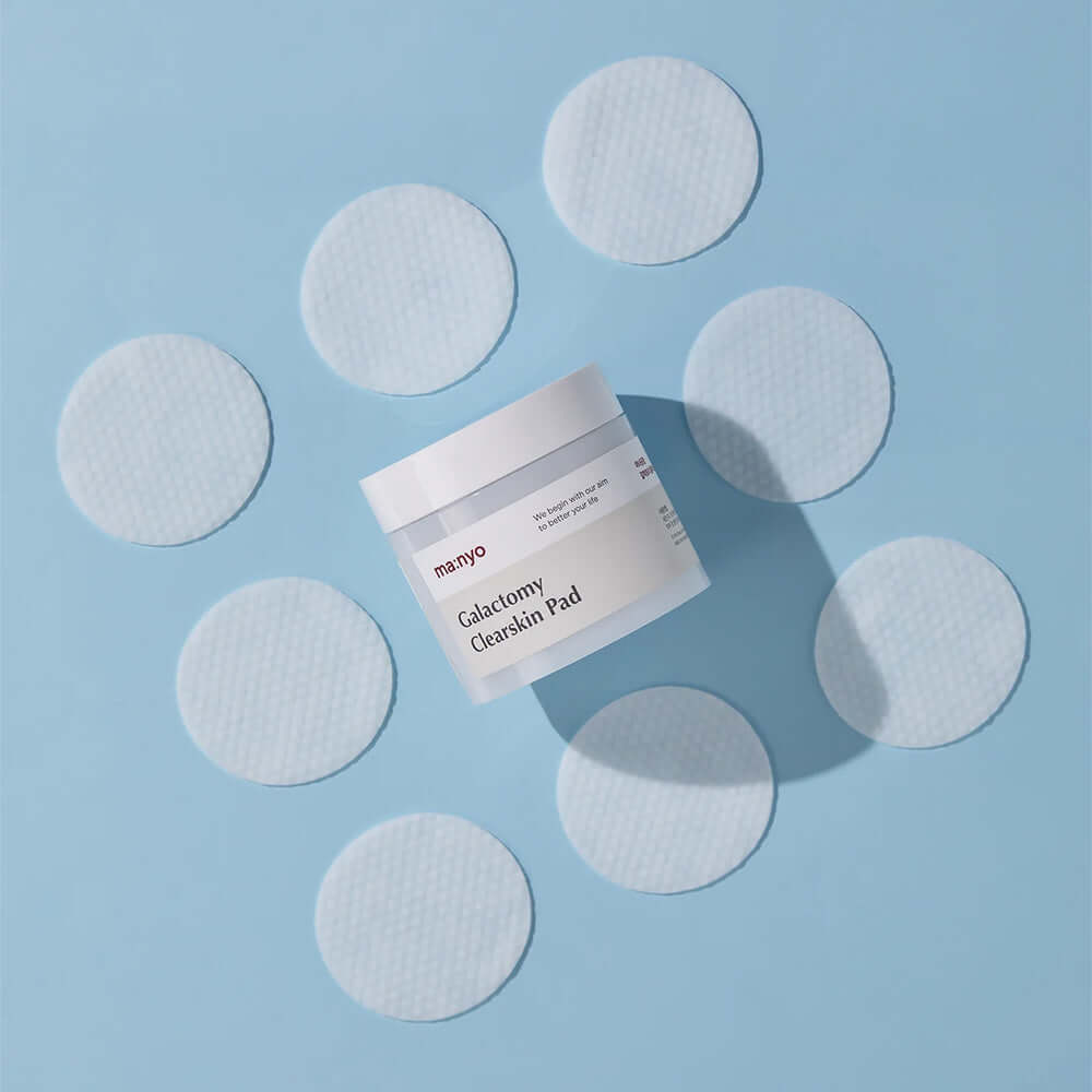 MANYO Galactomy Clear Skin Pads 60 sheets jar surrounded by open pad circles on a blue background.