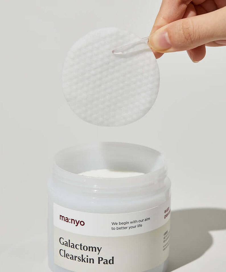 MANYO Galactomy Clear Skin Pads 60 sheets shown in a clear jar with a hand holding a pad.