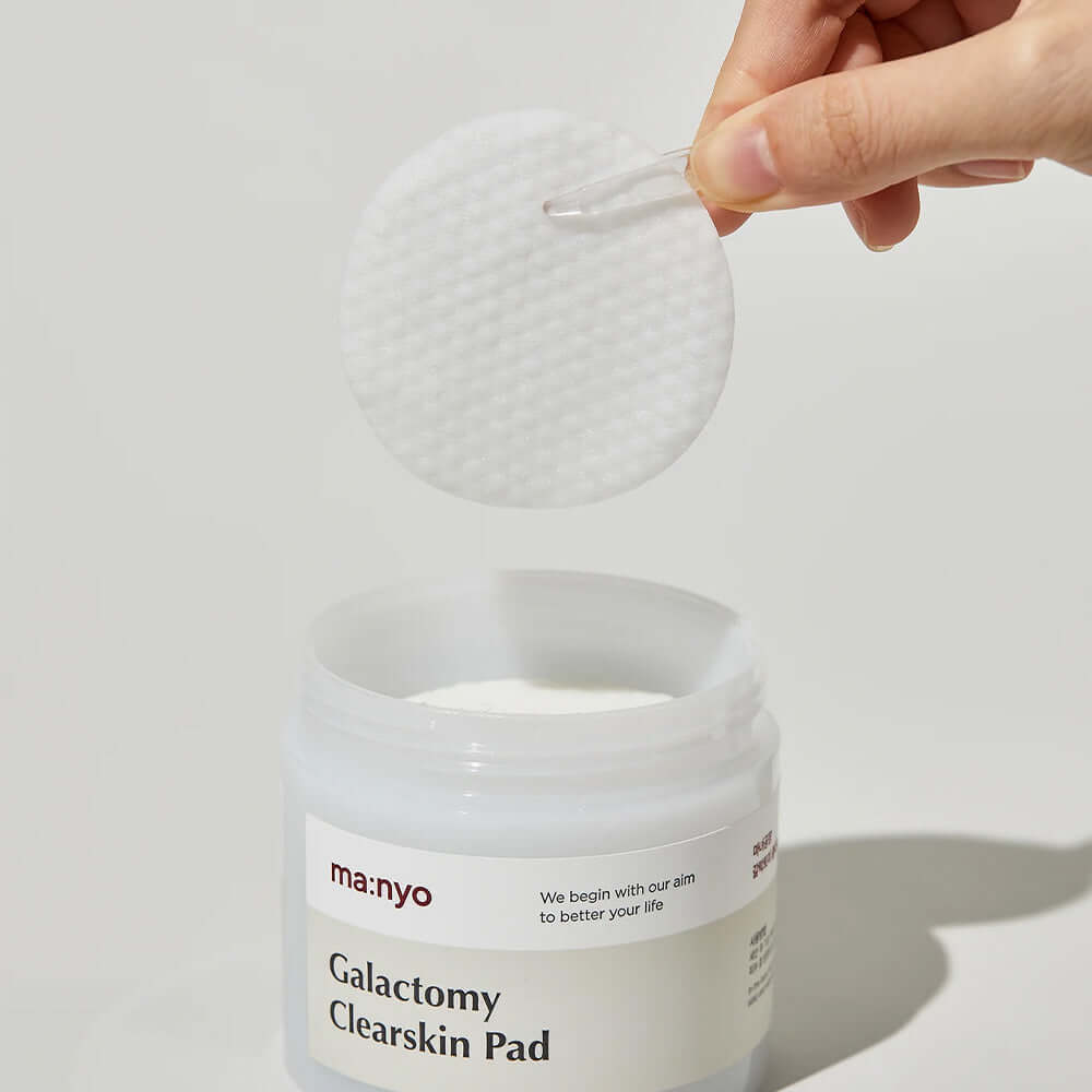 MANYO Galactomy Clear Skin Pads 60 sheets shown in a clear jar with a hand holding a pad.