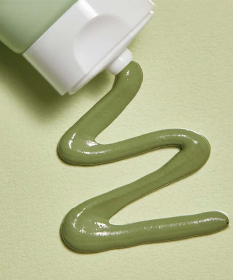 MANYO Herb Cica Pack 75ml squeezed from tube showcasing its smooth green texture on a matching background.