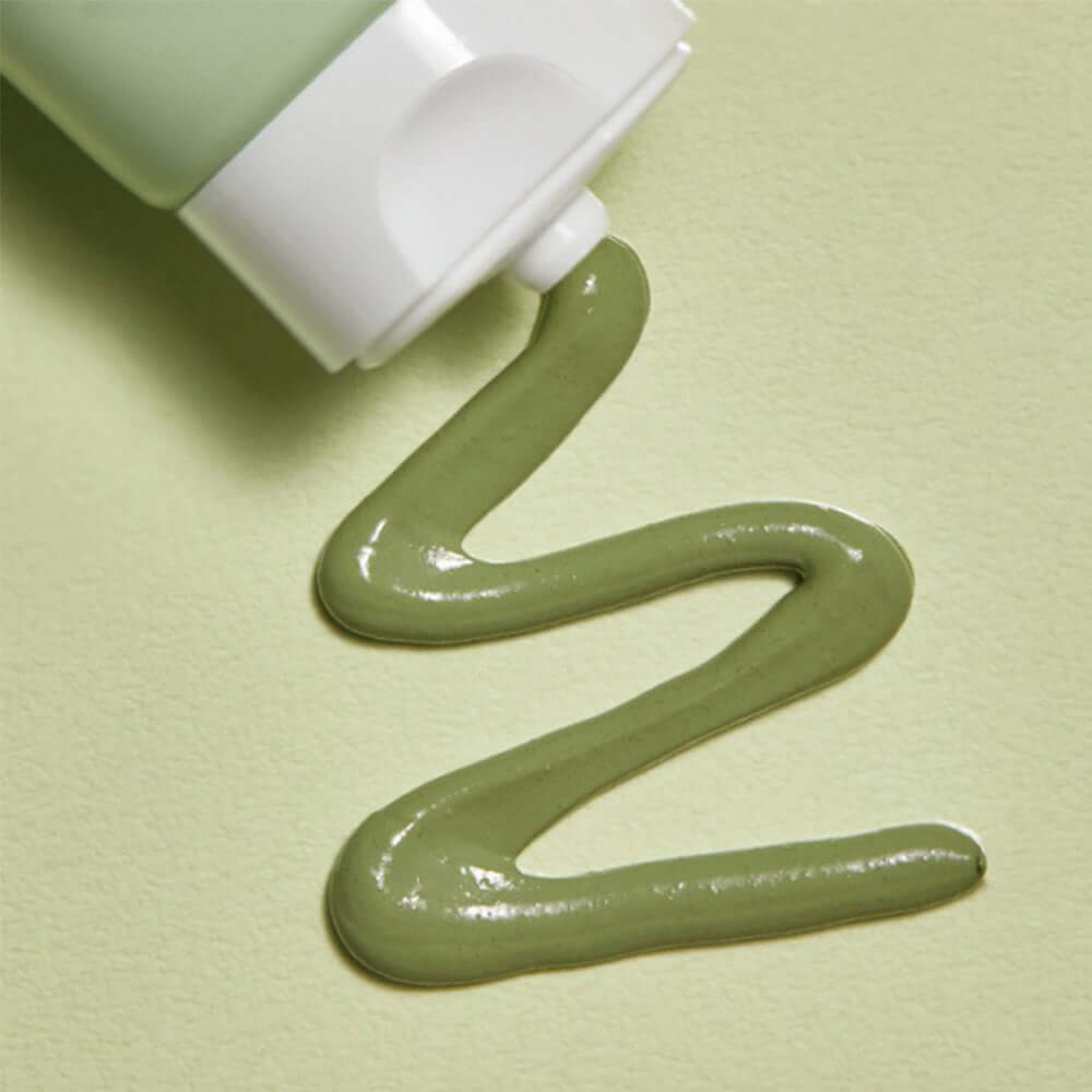 MANYO Herb Cica Pack 75ml squeezed from tube showcasing its smooth green texture on a matching background.