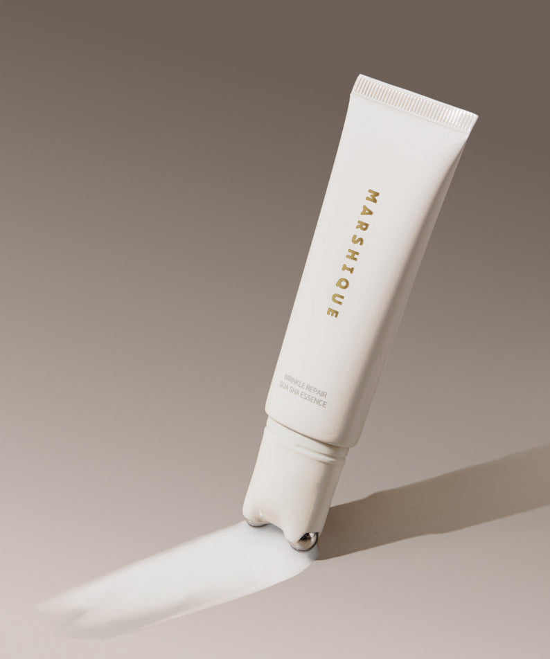 MARSHIQUE Wrinkle Repair Guasha Essence 45ml tube with applicator on a gradient background.