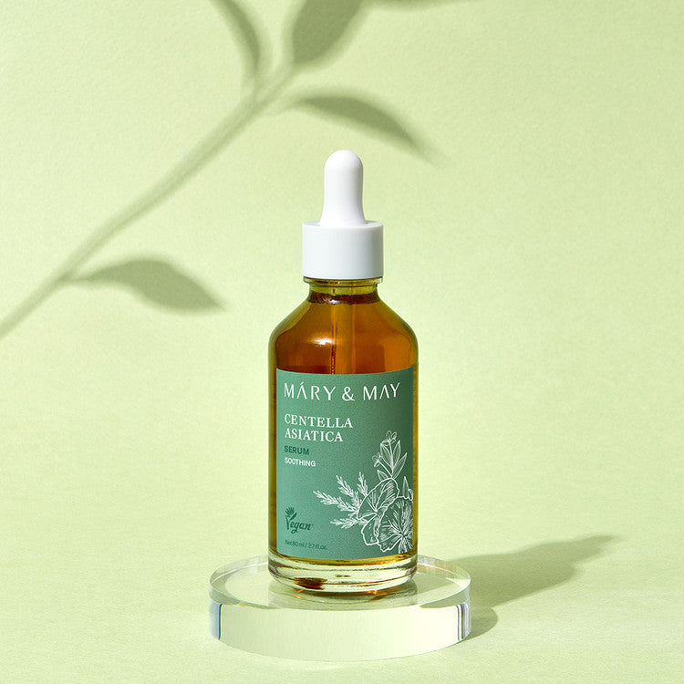 MARY&MAY Herbal Extract Serum 80ml bottle on a glass stand with a green background.