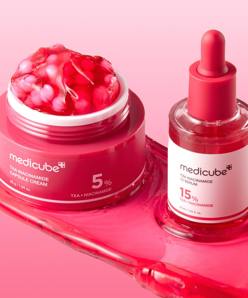 MEDICUBE TXA Trace Toning Serum 30ml next to MEDICUBE TXA Niacinamide Capsule Cream on a pink background.
