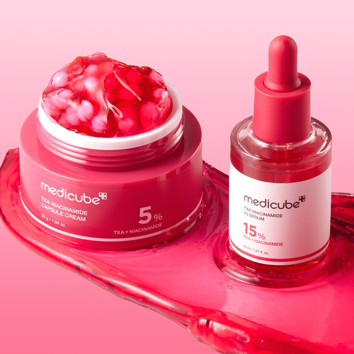 MEDICUBE TXA Trace Toning Serum 30ml next to MEDICUBE TXA Niacinamide Capsule Cream on a pink background.
